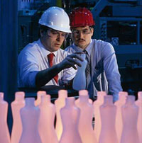 Two men inspecting bottles coming off the assembly line